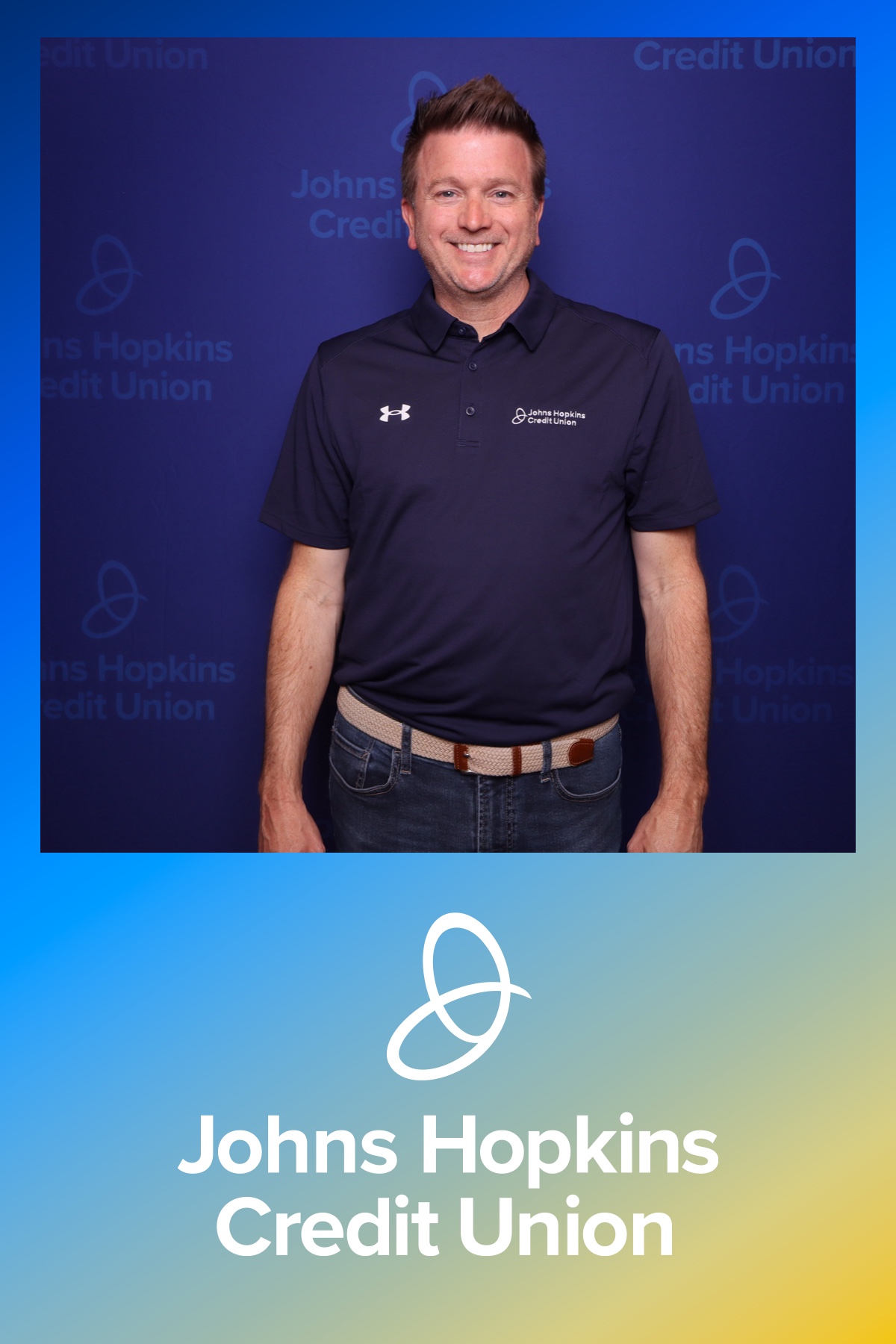 Johns Hopkins Credit Union employee at branded backdrop