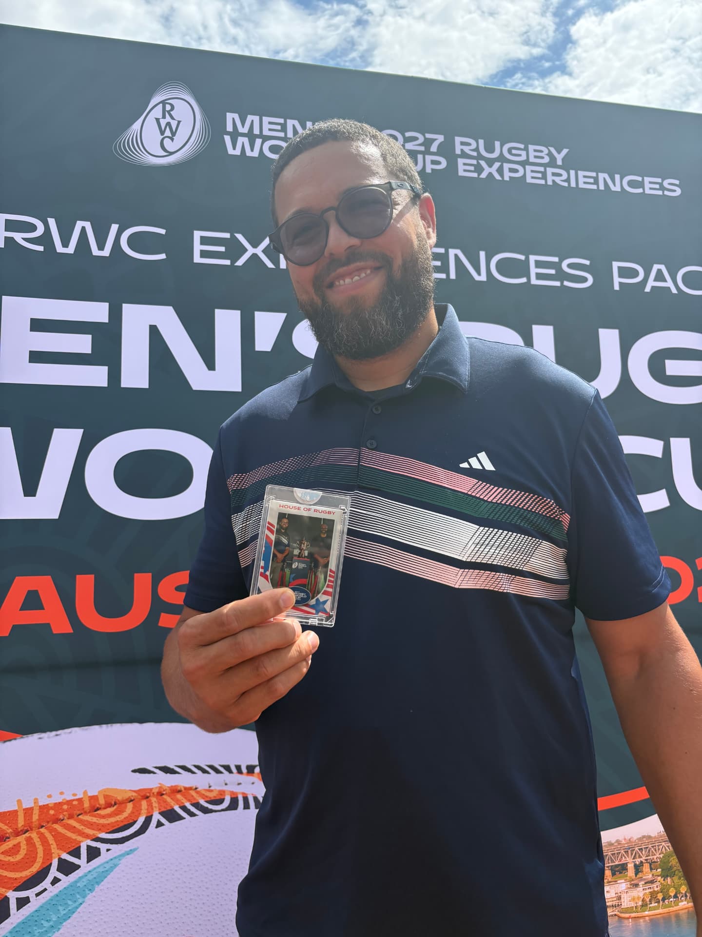 Guest holding his custom rugby trading card at the World Rugby fan experience
