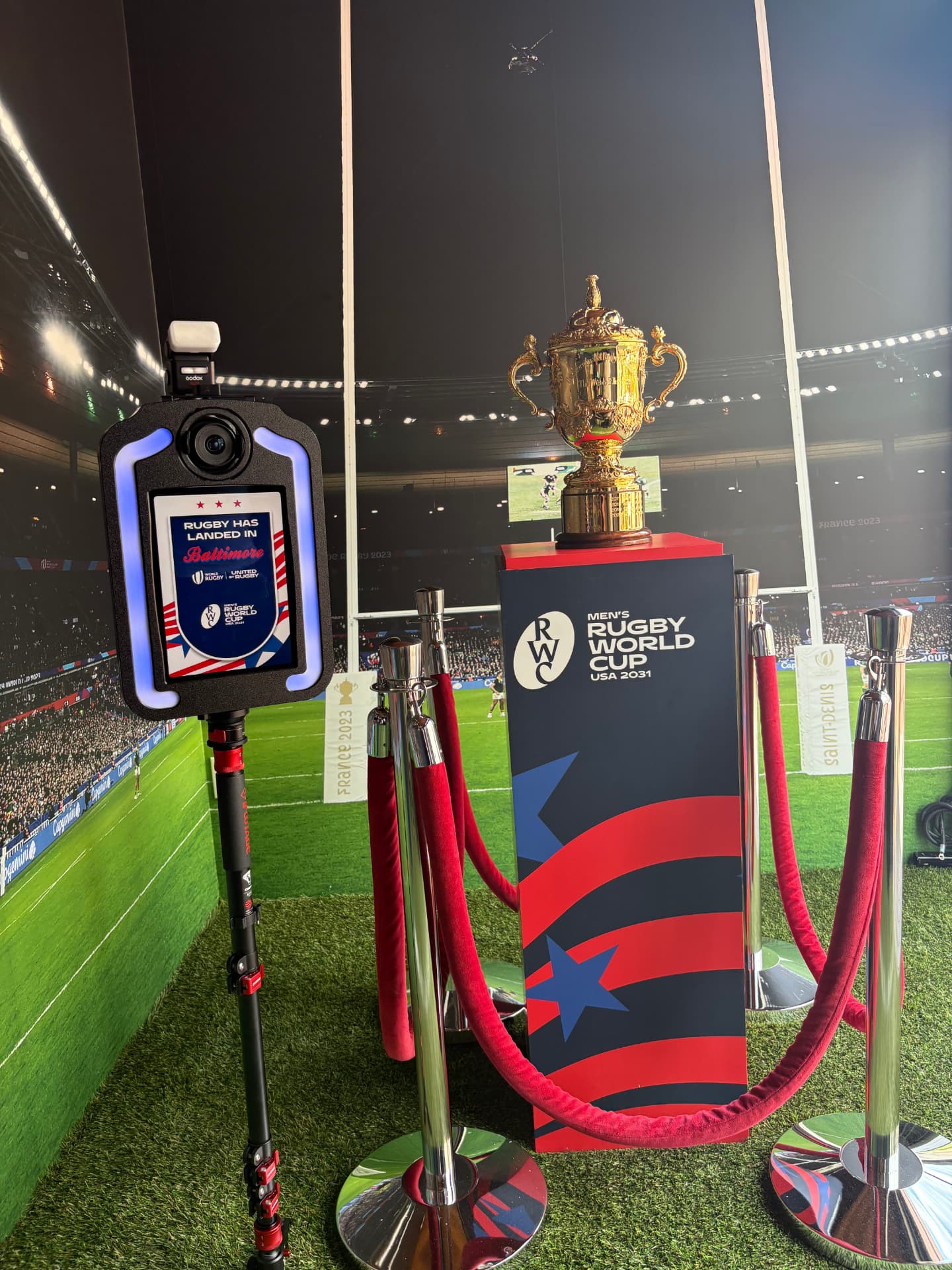 Branded photo booth beside the Webb Ellis Cup display inside M&T Bank Stadium