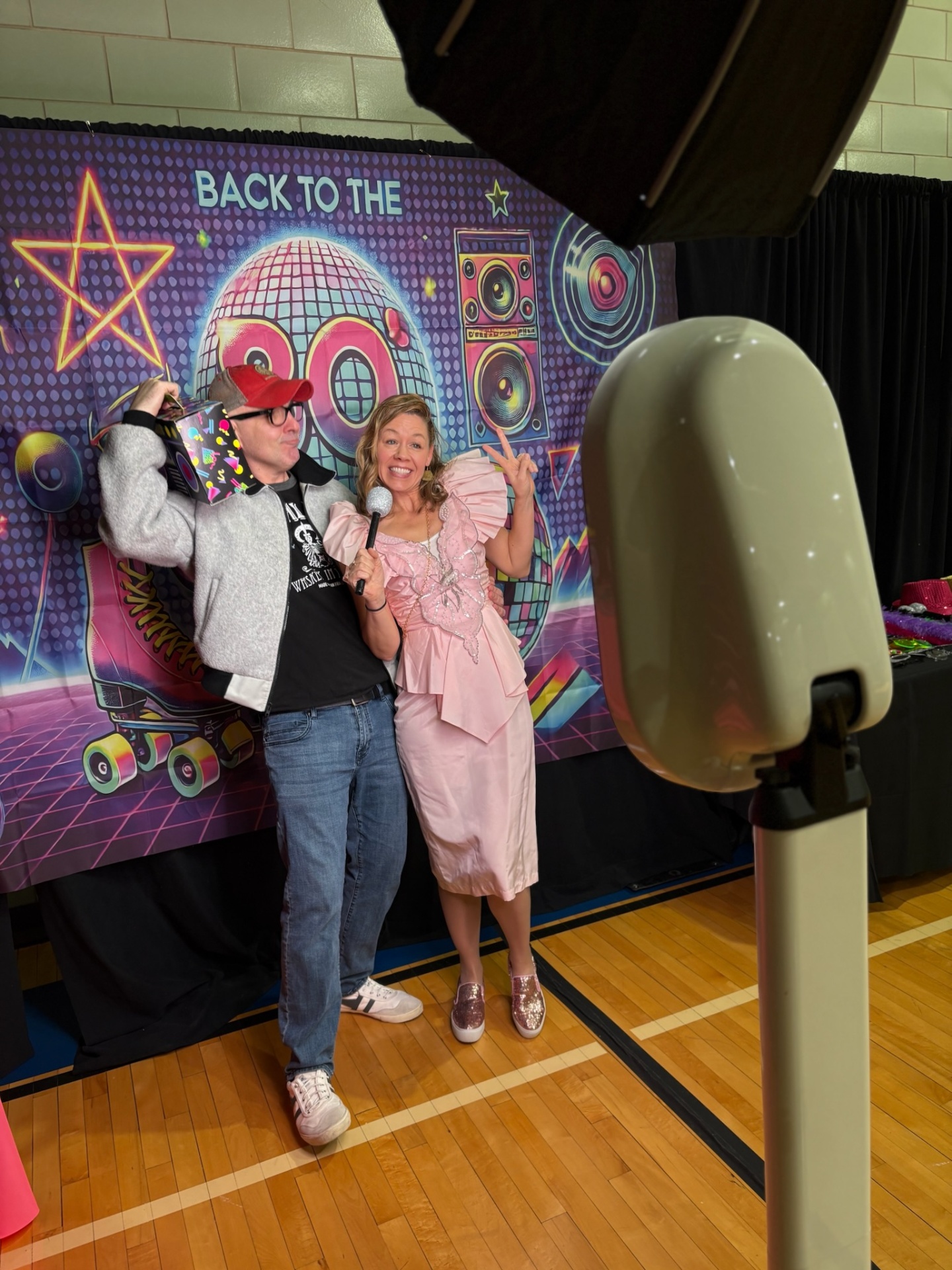Couple posing at 80s themed selfie booth